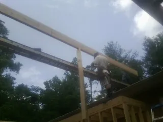 Carpenter setting a ridge beam over a new addition frame — Ice Dam Removal by Roofing Brothers in North Smithfield