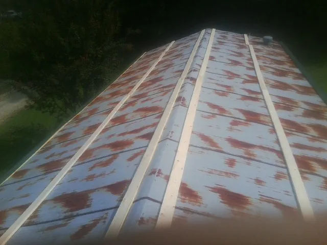 Rusted metal roof panels with new wood purlins before replacement — Storm Damage Roof Repair in North Smithfield by Roofing Brothers