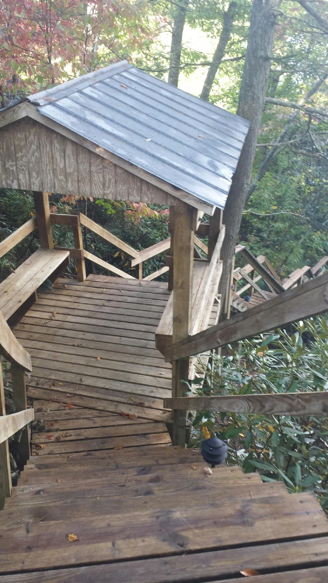 Metal roofed shelter over wooden steps on a wooded walkway — Skylight Repair & Installation work by our crew in North Smithfield