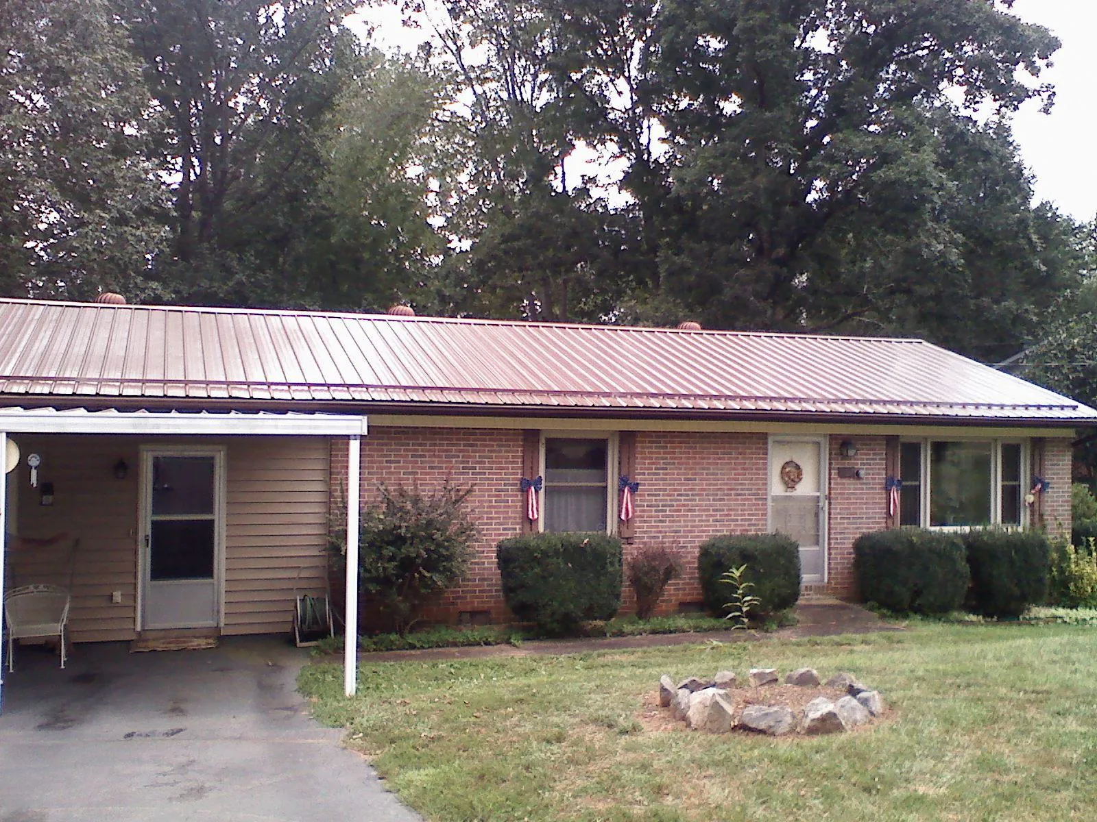 Bronze metal roof and carport on a brick ranch home — Roof Repair work by our crew in North Smithfield